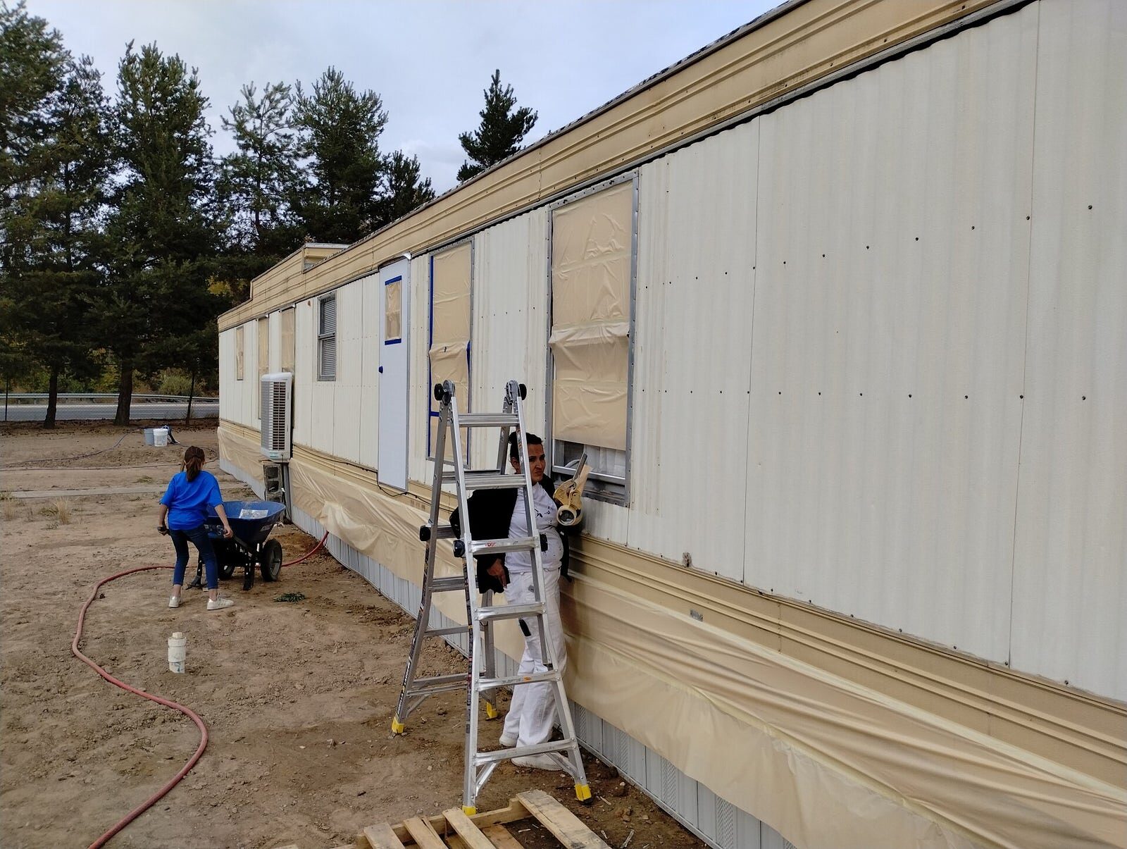 Aragon's crew painting a home exterior in San Juan County, NM