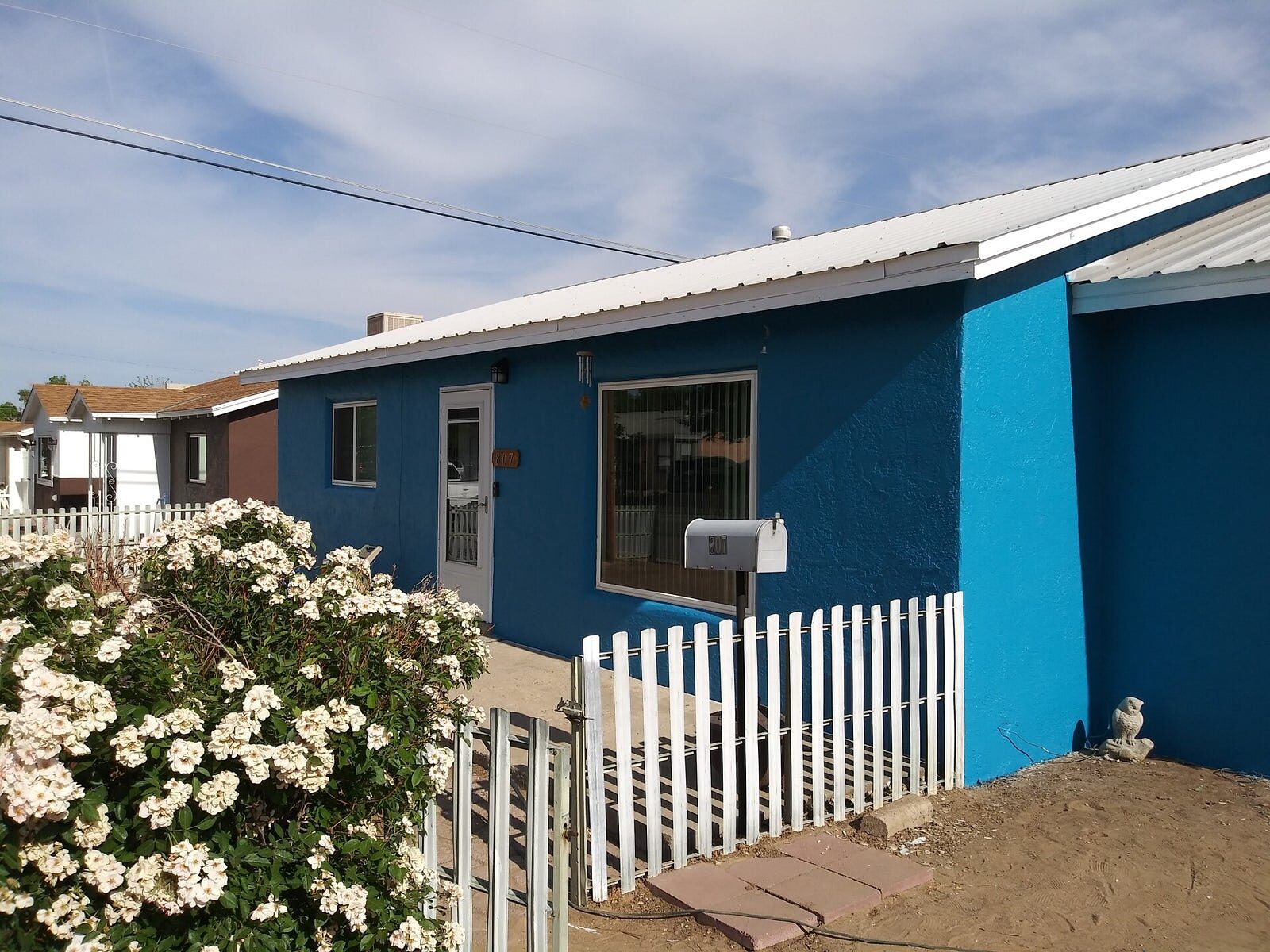Blue home exterior with crisp white trim and picket fence